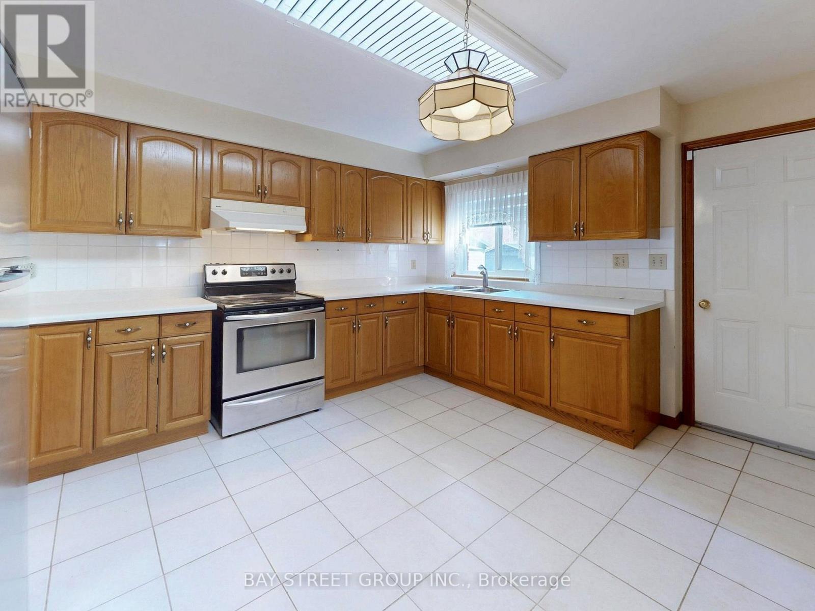A kitchen with wooden cabinets and a white tile floor.