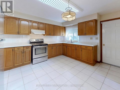 A kitchen with wooden cabinets and a white tile floor.