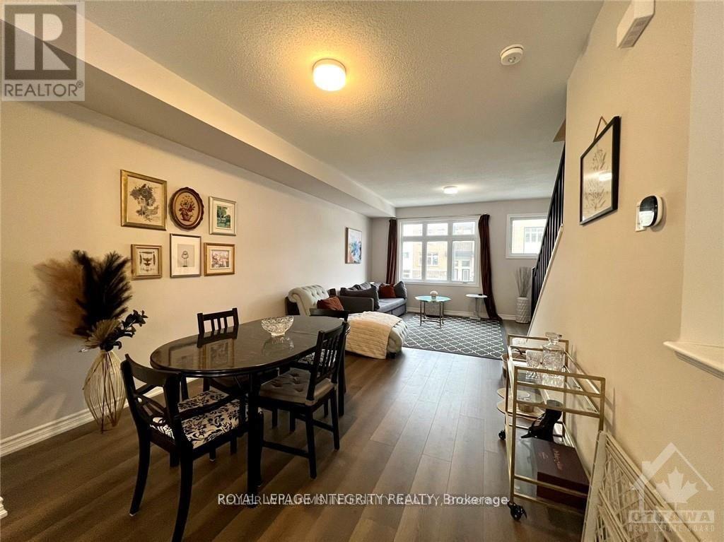 A dining room with a table set for six and a couch in the background.