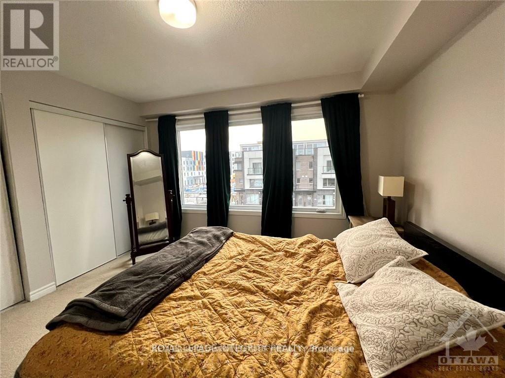 A bedroom with a large bed and a window with black curtains.
