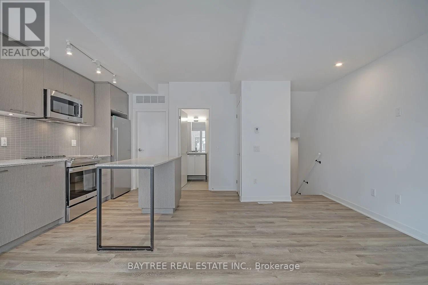 A real estate listing photo of a kitchen and living room.