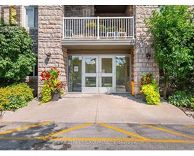 The entrance to a building with a glass door and a balcony.