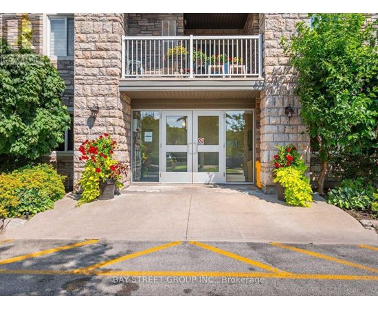 The entrance to a building with a glass door and a balcony.