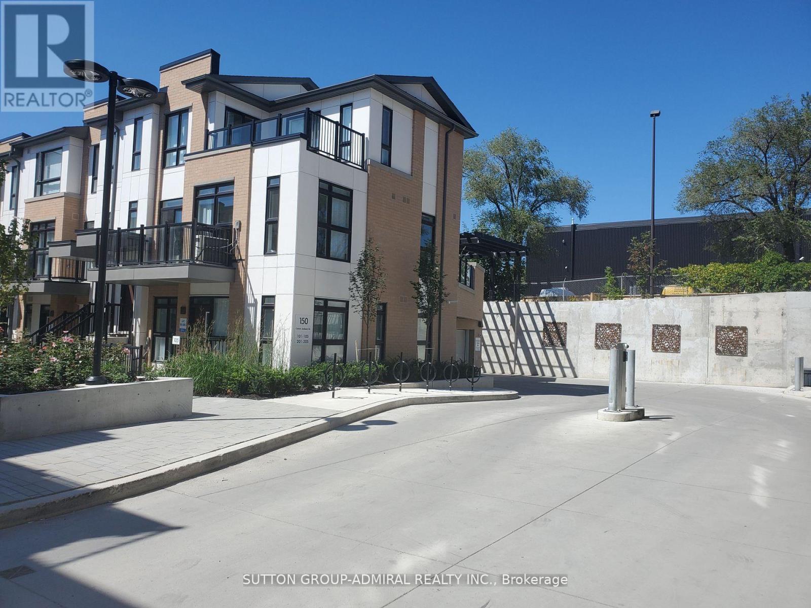 A row of modern townhouses with a clear blue sky above.