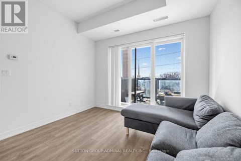 A living room with a grey couch and a large window.