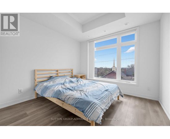 A bedroom with a bed and a window overlooking a church.