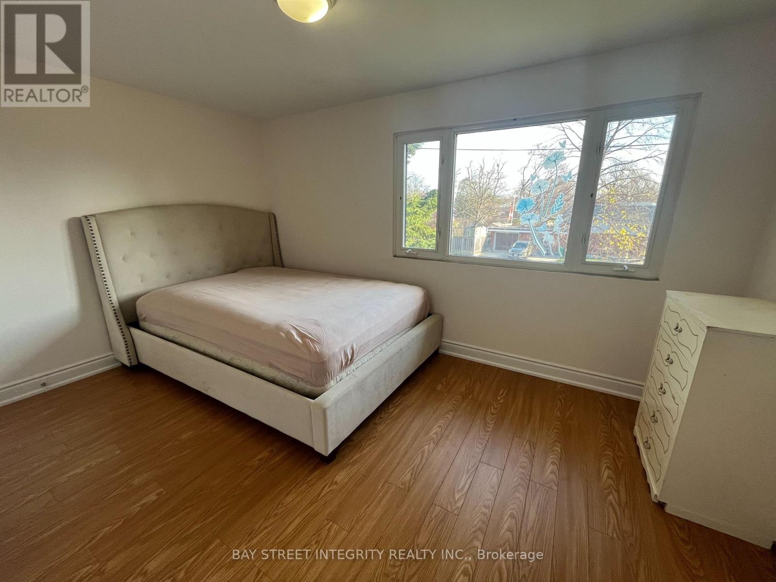 A bedroom with a large bed and a window overlooking a construction site.