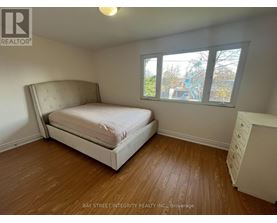 A bedroom with a large bed and a window overlooking a construction site.