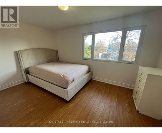 A bedroom with a large bed and a window overlooking a construction site.