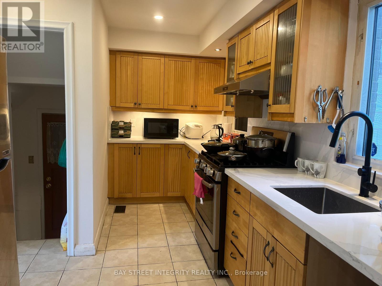 A kitchen with wooden cabinets and a black stove top.