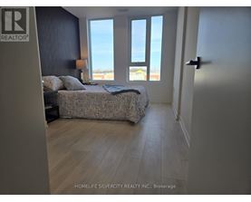 A bedroom with a large bed and a view of the ocean through the windows.