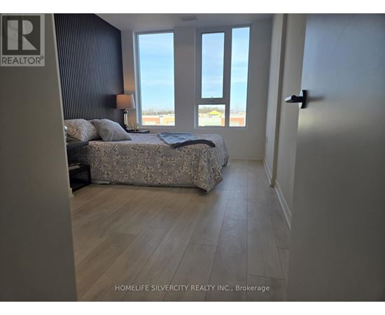 A bedroom with a large bed and a view of the ocean through the windows.