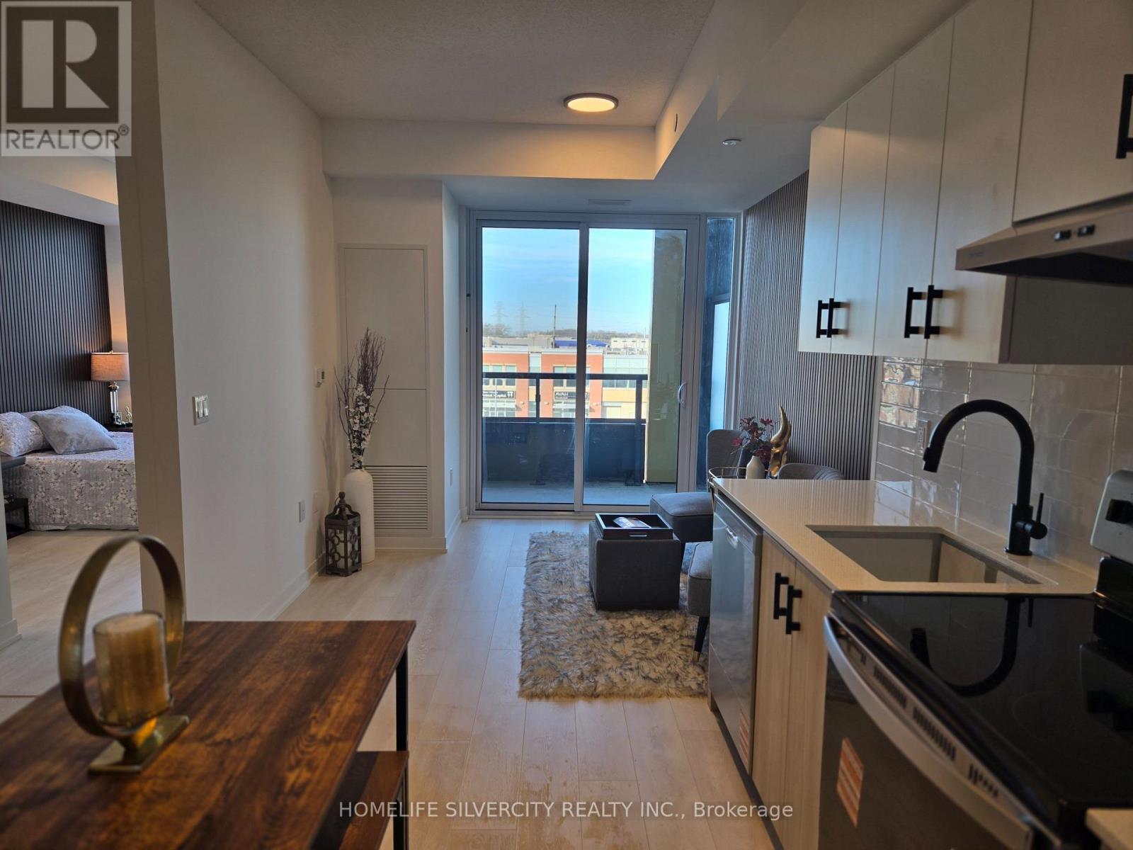 A modern kitchen with a wooden table and a view of the city.