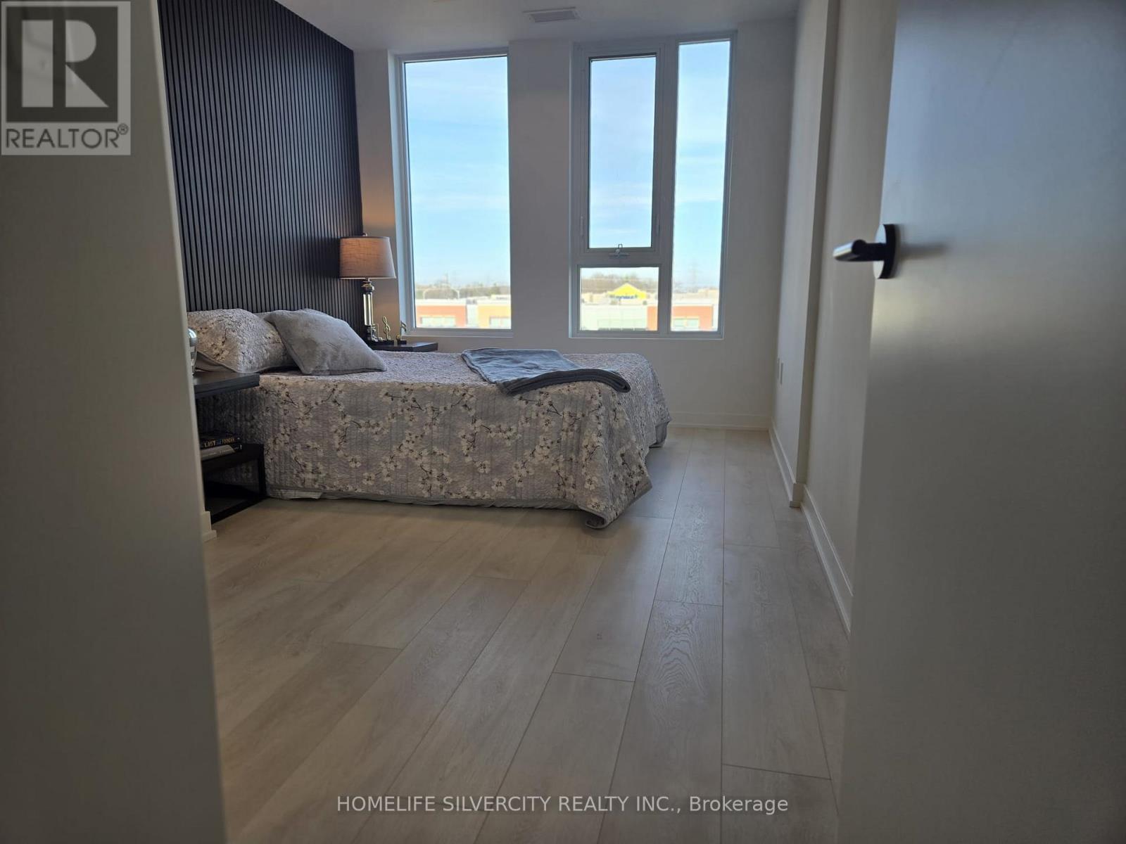 A bedroom with a large bed and a view of the ocean through the windows.