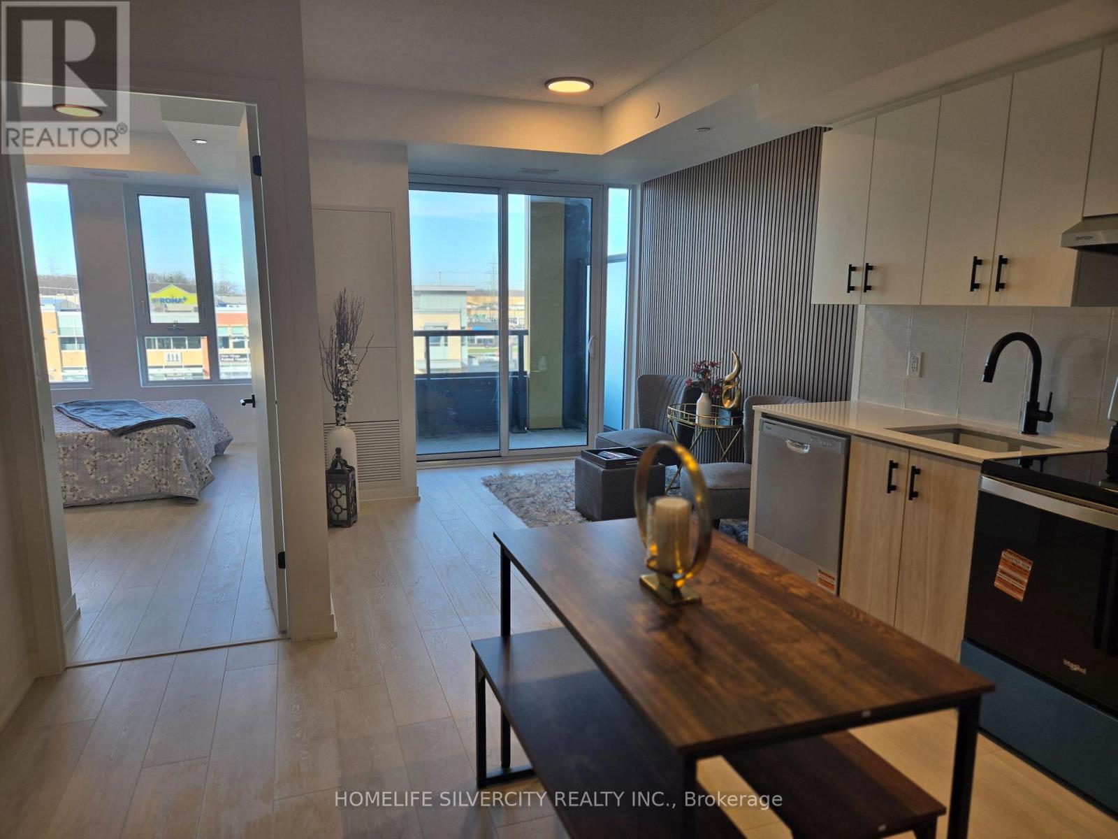 A modern kitchen with a wooden table and a view of the city.