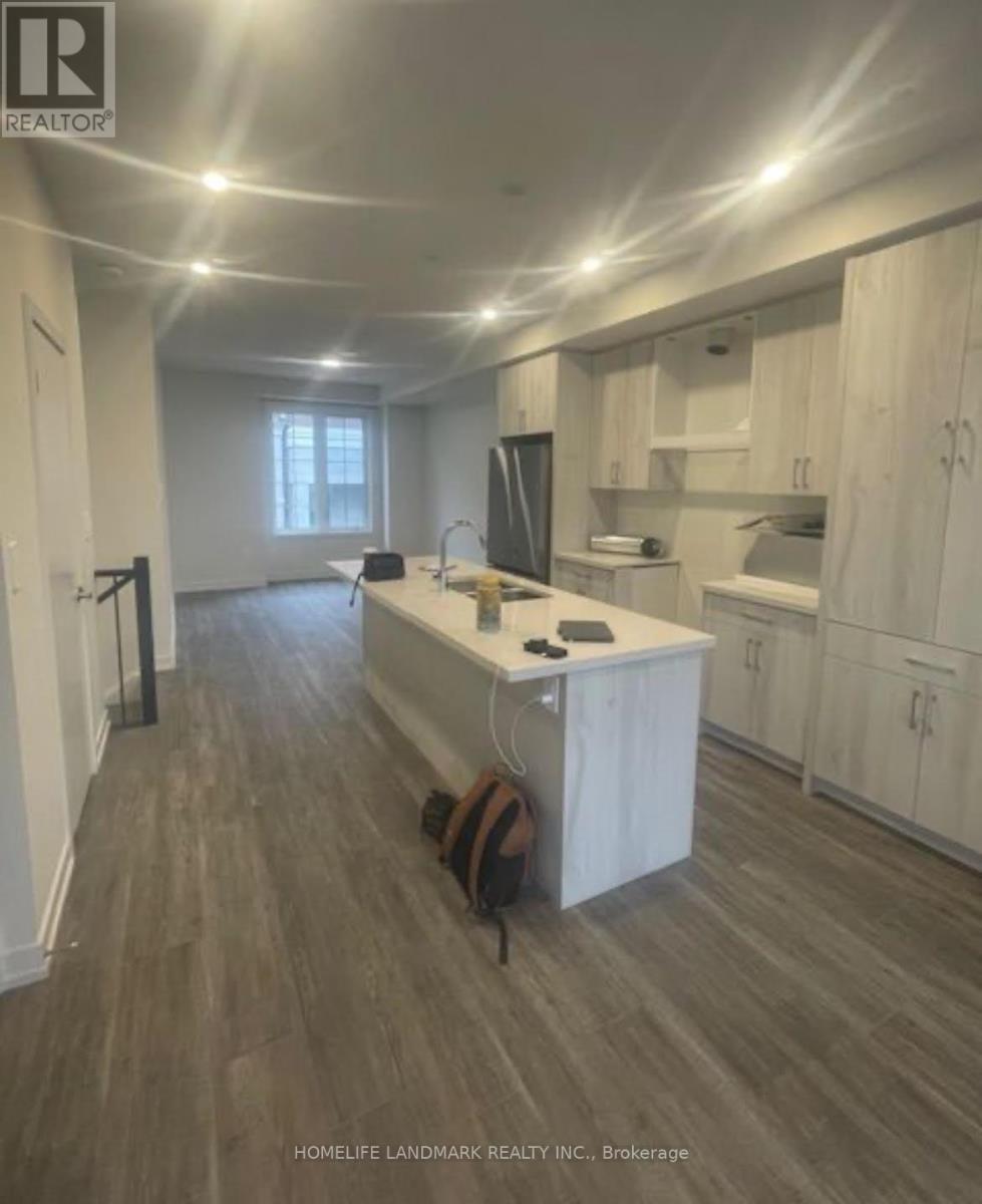 A well-lit kitchen with wooden floors and white cabinetry.