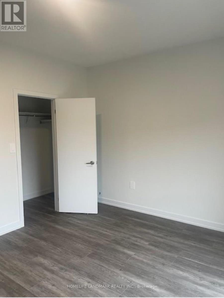 A room with a white door and wooden flooring.