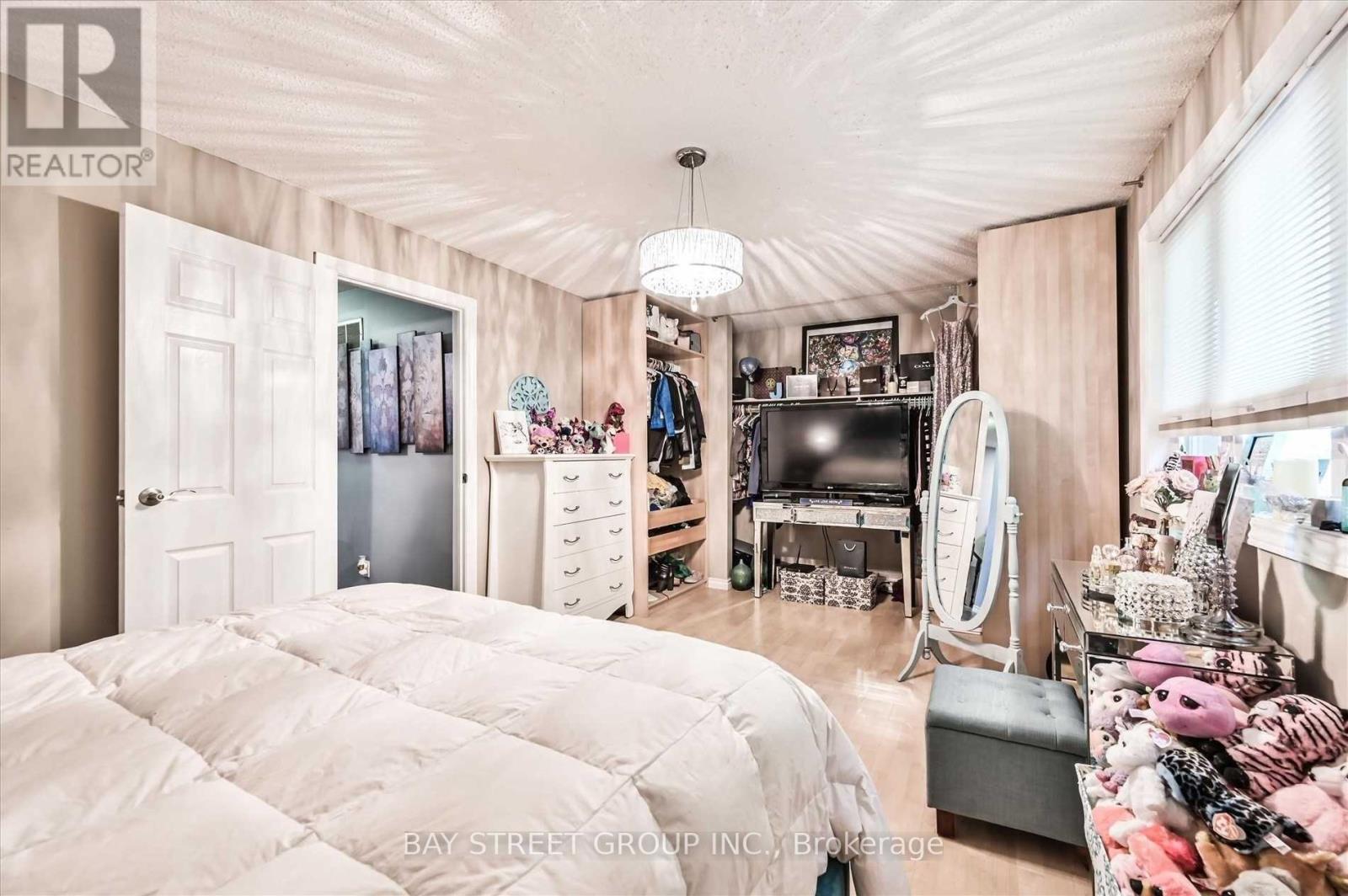A bedroom with a large bed and a vanity with a mirror.