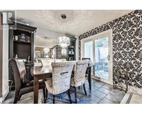 A dining room with a table set for two and a chandelier hanging from the ceiling.