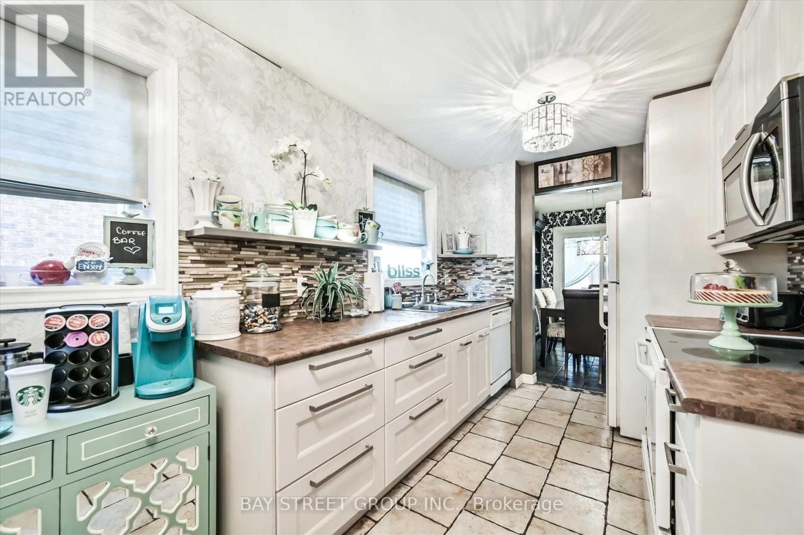 A kitchen with white cabinets and a brown countertop.