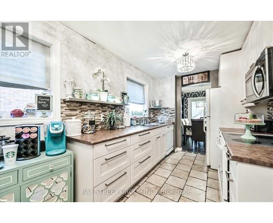 A kitchen with white cabinets and a brown countertop.