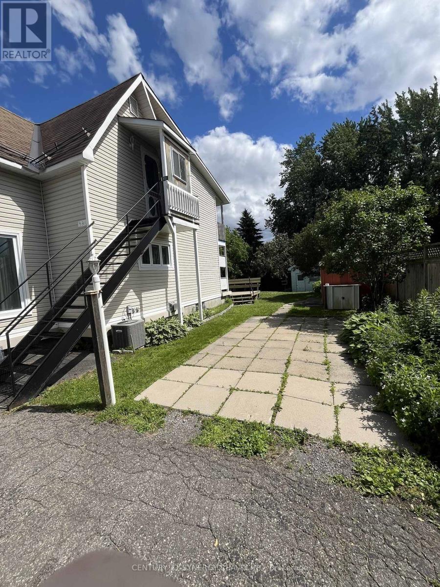 A house with a patio and a staircase leading to the roof.