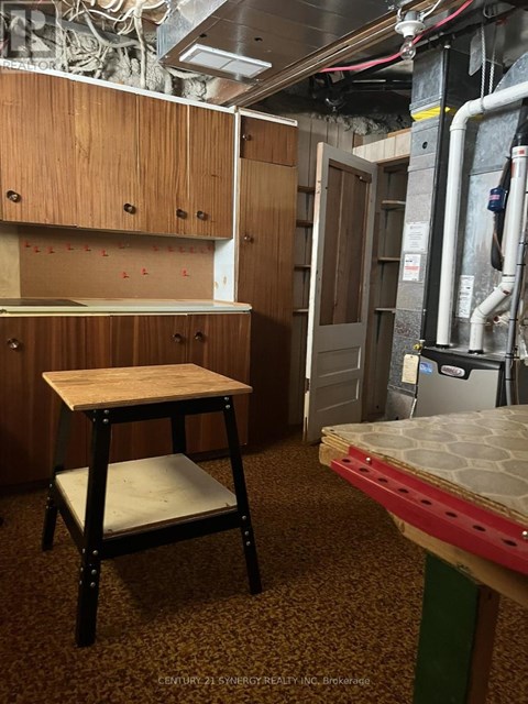 A kitchen area with a table and a stool.