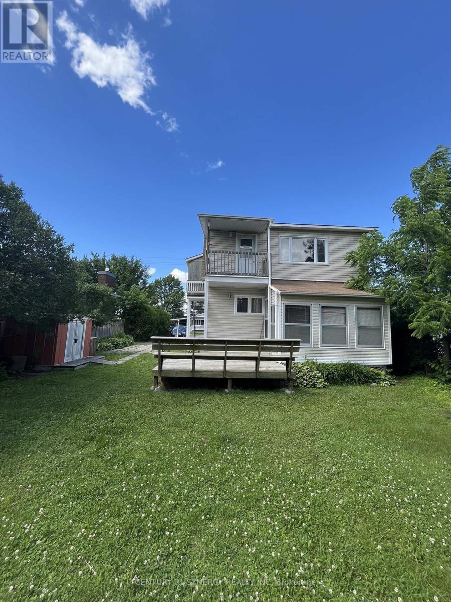 A house with a balcony and a bench in the yard.