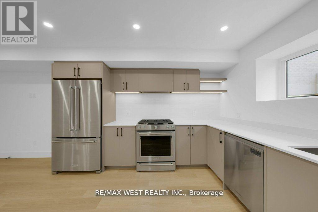 A kitchen with a refrigerator, oven, and microwave.