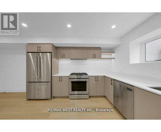A kitchen with a refrigerator, oven, and microwave.