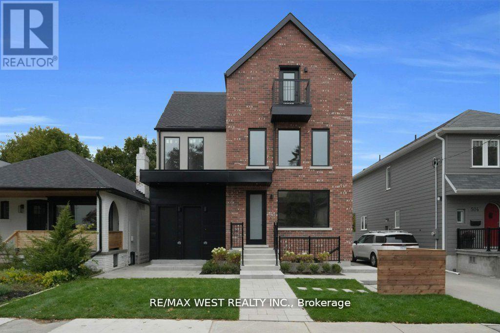 A house with a brick facade and a black door is for sale.
