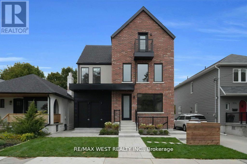 A house with a brick facade and a black door is for sale.