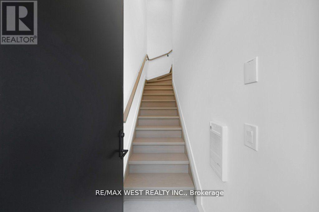 A staircase in a building with a logo on the wall.