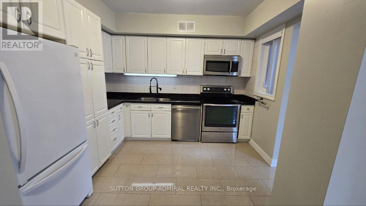 A kitchen with white cabinets and appliances.