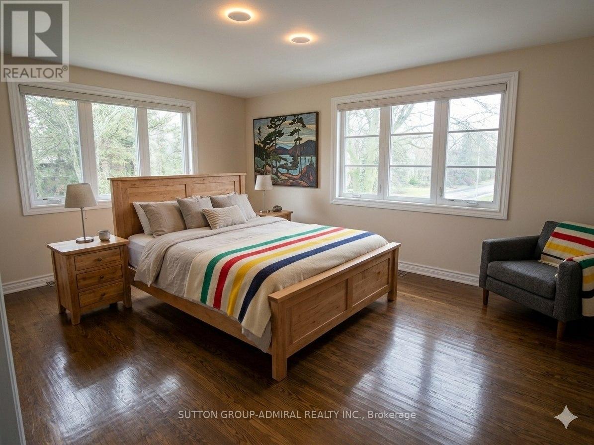 A bedroom with a large bed and a chair.