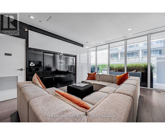 A modern living room with a large couch and a television.