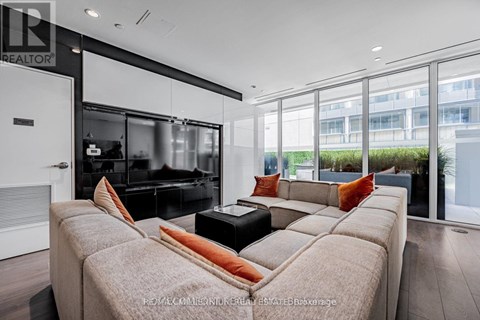 A modern living room with a large couch and a television.