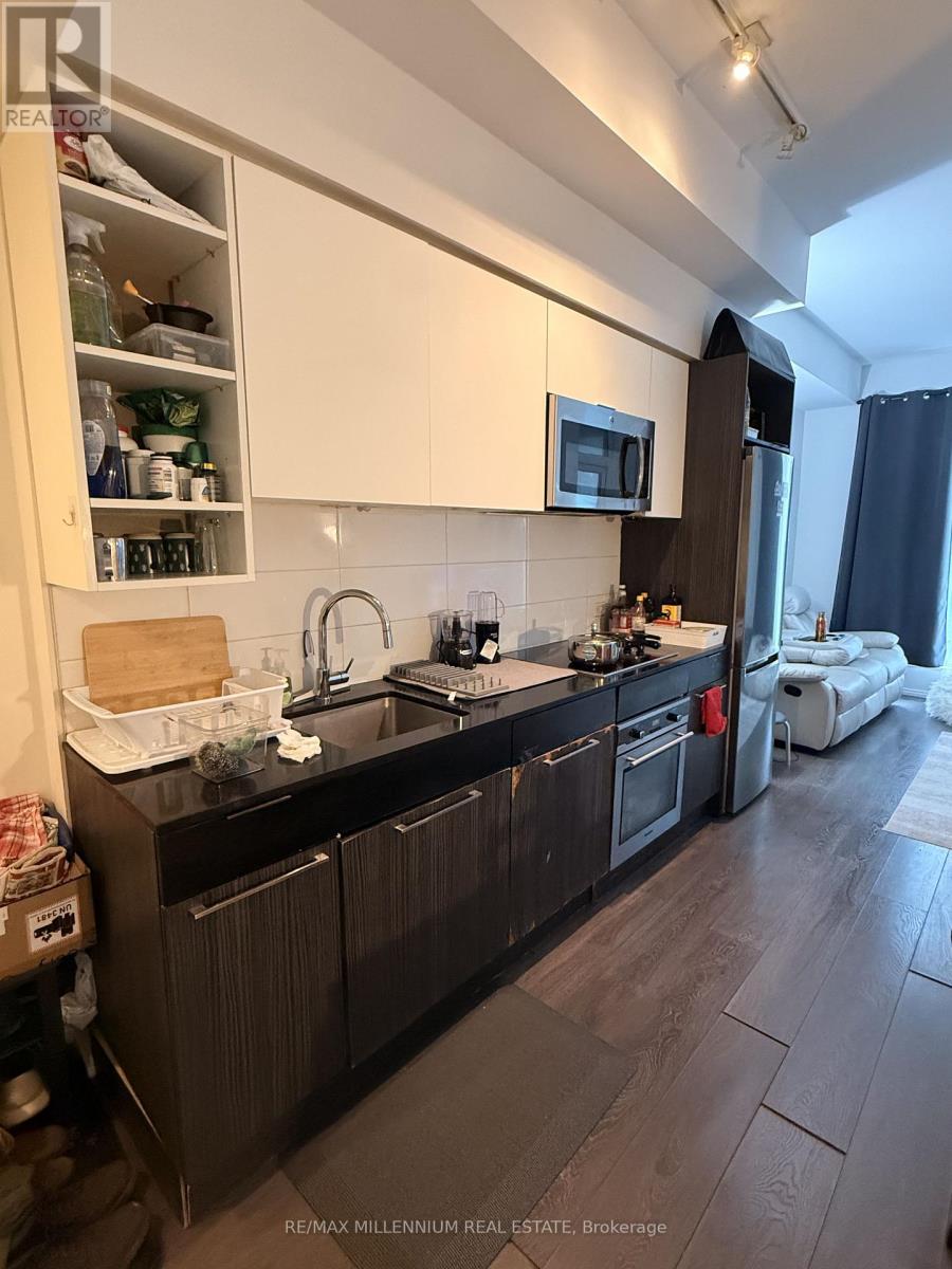 A kitchen with dark wood floors and white cabinets.
