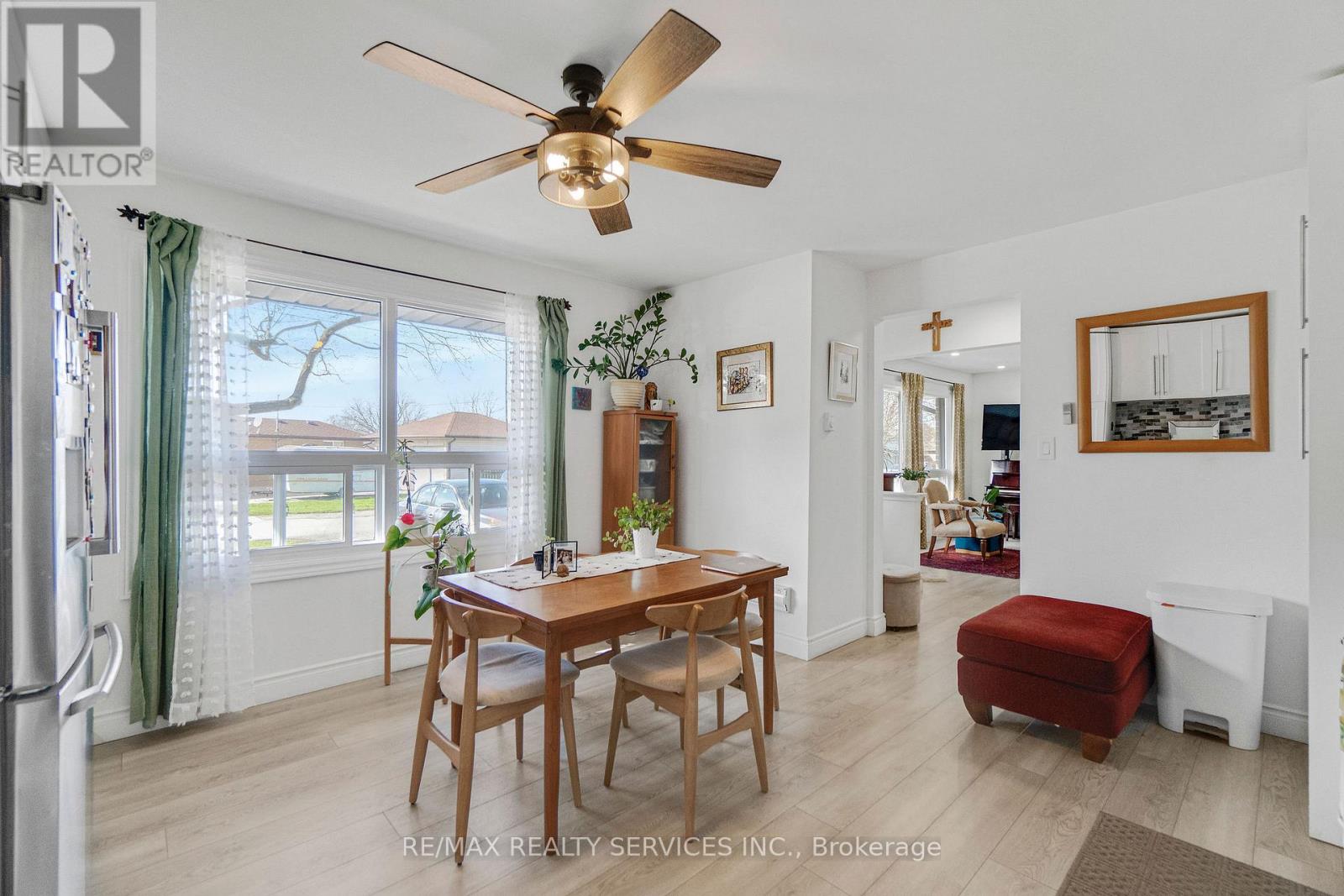 A dining room with a table and chairs and a ceiling fan.