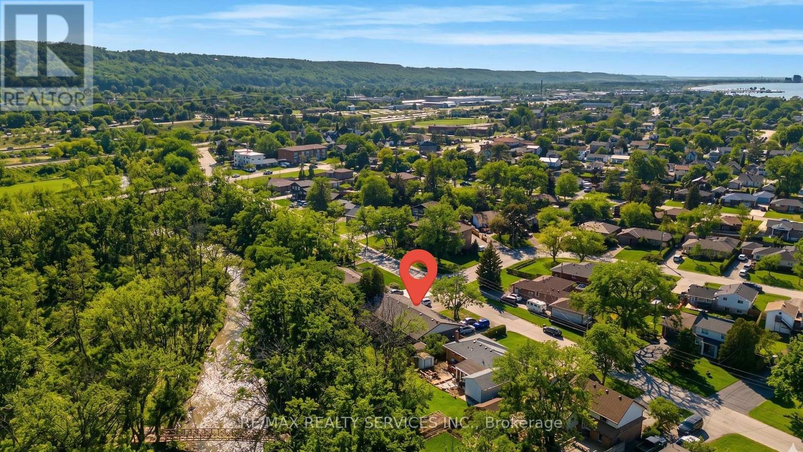 A red pin marks a location in a suburban area with houses and trees.