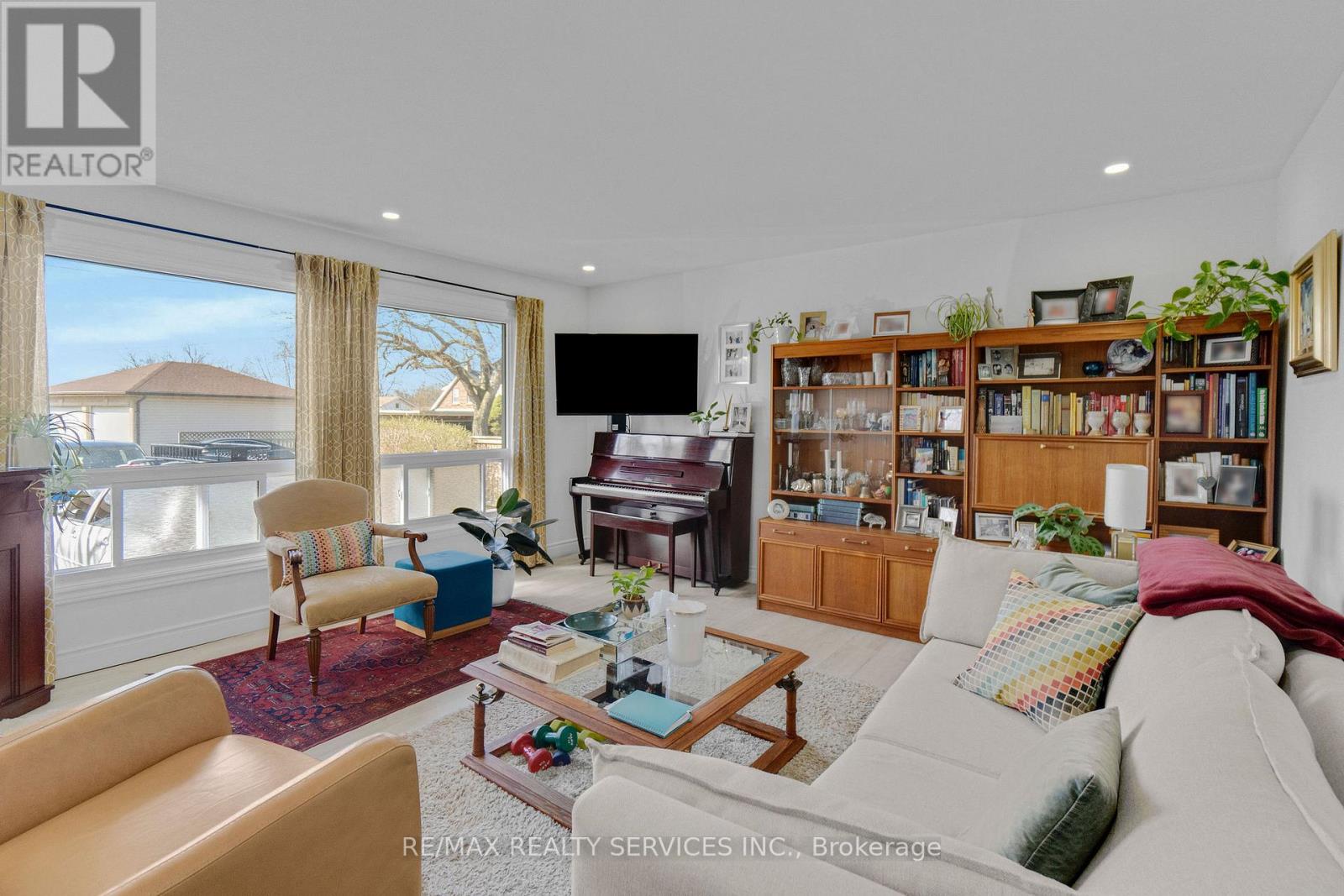 A living room with a white couch and a bookshelf filled with books.