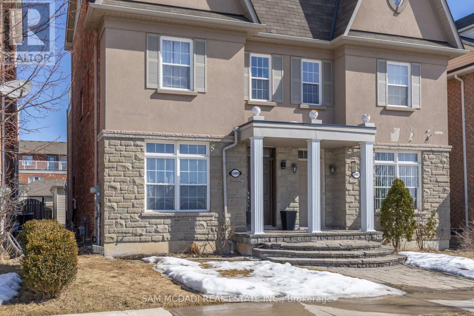 A house with a front yard and a snow-covered ground.