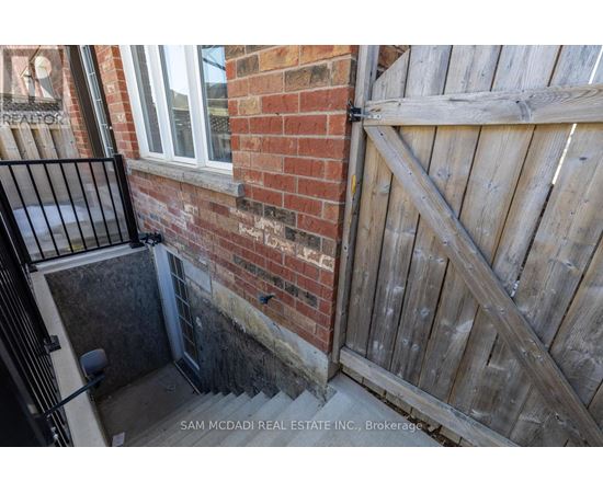 A wooden gate is closed to a brick wall.