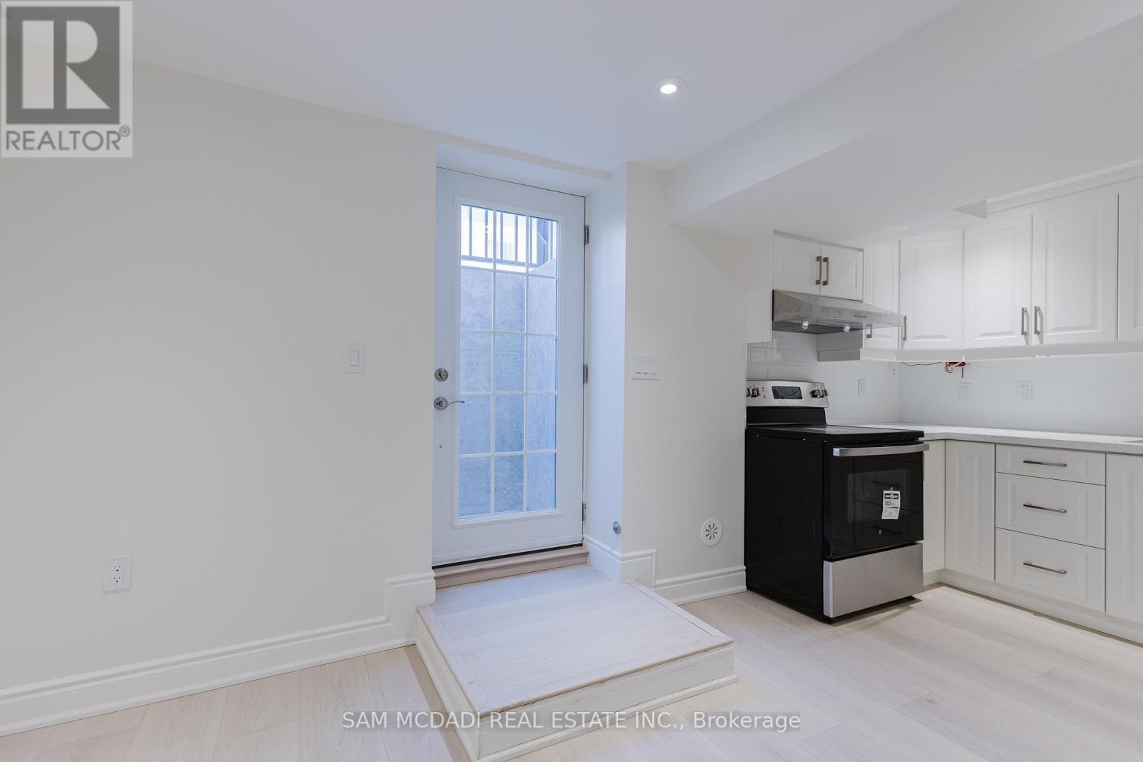 A white kitchen with a black oven and white cabinets.