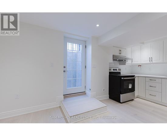 A white kitchen with a black oven and white cabinets.