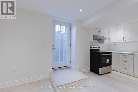A white kitchen with a black oven and white cabinets.