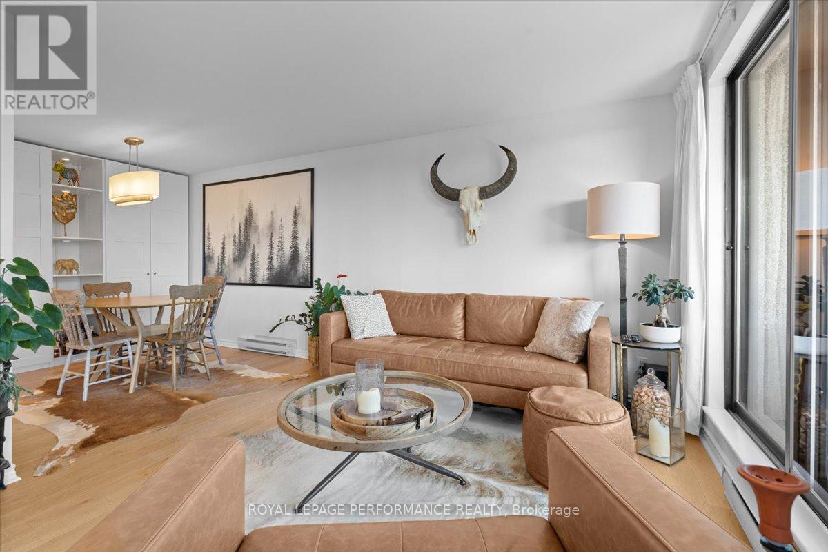 A living room with a couch, coffee table, and a painting on the wall.
