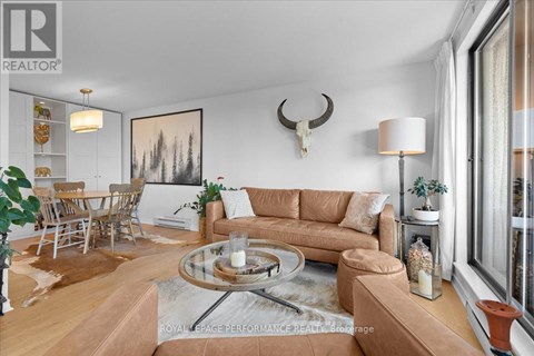 A living room with a couch, coffee table, and a painting on the wall.