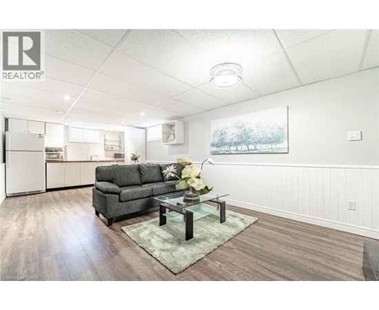 A living room with a grey couch and a glass coffee table.