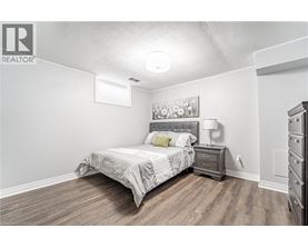 A bedroom with a bed, nightstand, and dresser.